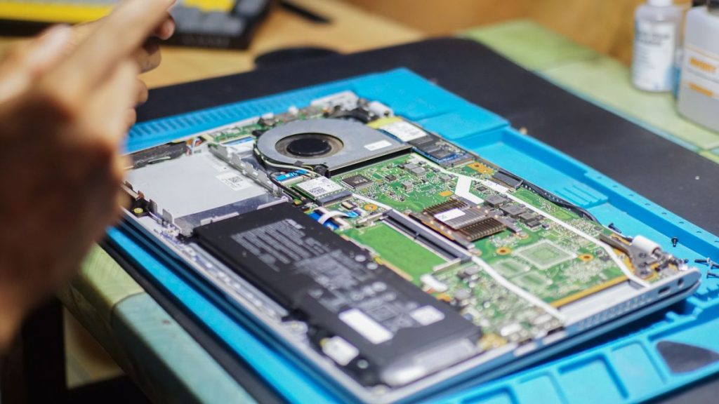 Laptop opened for repair with the battery and internal components visible