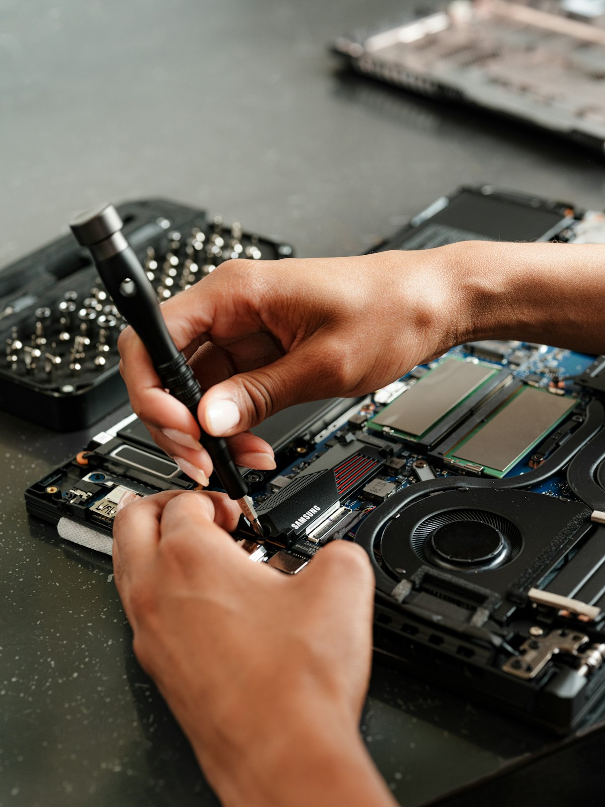 Technician using a precision screwdriver inside an open laptop