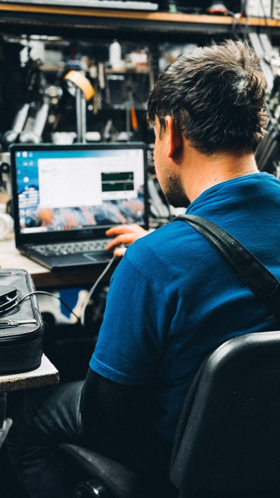 Technician working on a laptop at a workbench